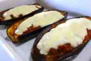 greek stuffed eggplant in a white casserole dish topped with creamy Béchamel sauce and mashed potatoes