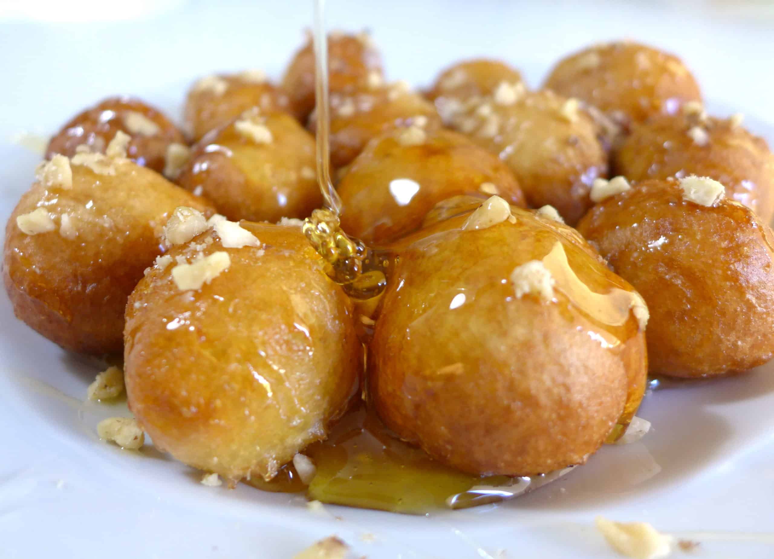 Greek donuts (Loukoumades) drizzled with honey and walnuts
